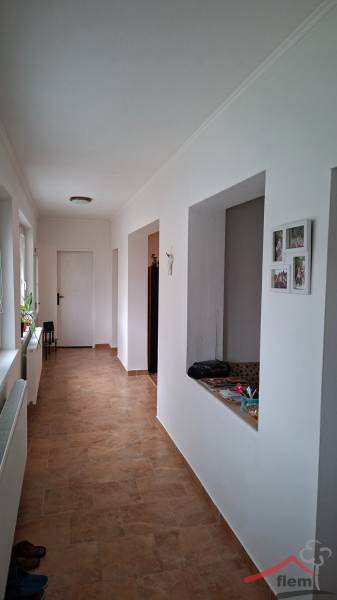 Dom na predaj Nová Ves nad Žitavou, pozemok 732 m2 - Chodba rodinného domu s dlažbou a bielymi stenami, s otvorenými dverami na pravej strane.