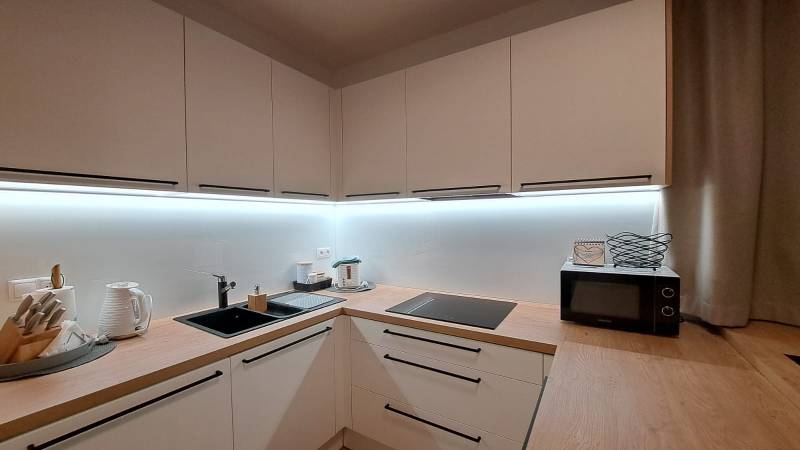 Lukratívny a priestranný 2-izbový apartmán v Mlynici na prenájom - Kuchyňa v 2-izbovom byte s dreveným dekorom a vybavením na varenie.