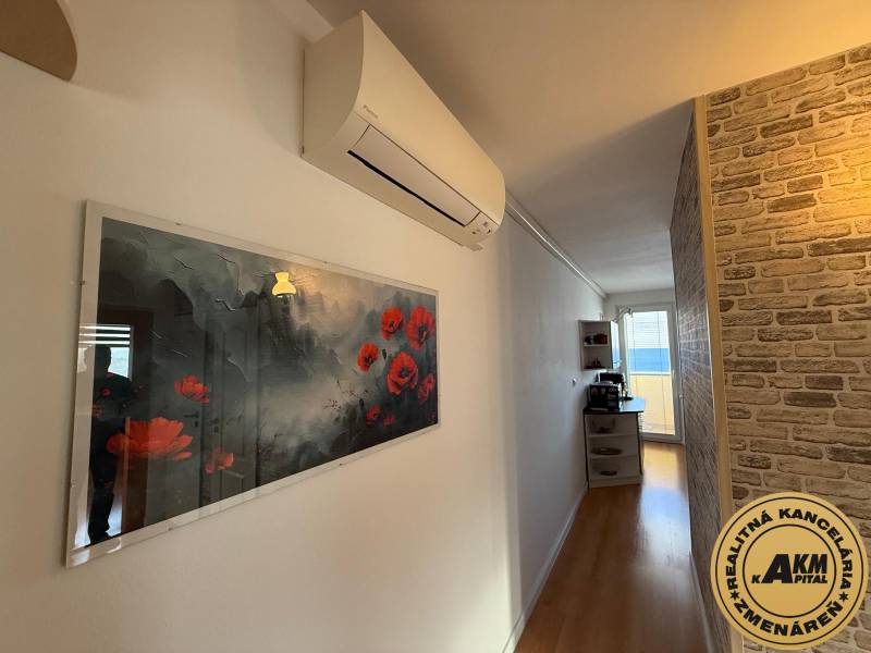 3 izbový byt 83 m² 2x balkón  Žiar nad Hronom centrum na predaj  - Chodba v 3-izbovom byte s podlahou s dreveným dekorom, dekoratívnou tehlovou stenou a klimatizáciou.