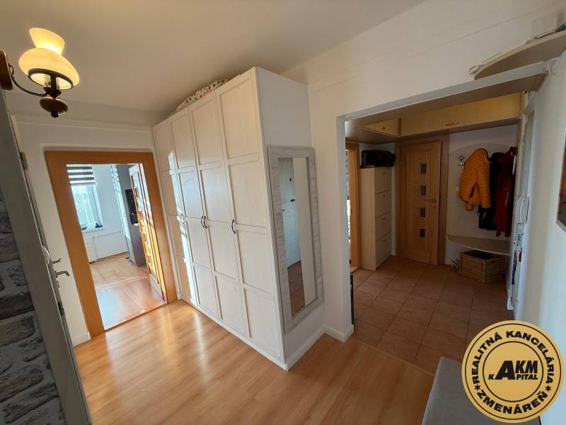 3 izbový byt 83 m² 2x balkón  Žiar nad Hronom centrum na predaj  - Chodba v 3-izbovom byte s podlahou s dreveným dekorom, bielymi skriňami a zrkadlom.