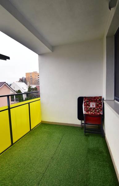 2 izbový byt na prenájom Dolný Šianec, Trenčín - Balkón 2-izbového bytu v Trenčíne na Dolnom Šianci, umelý trávnik a stoličky.
