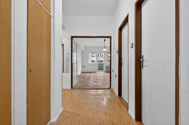 I PREDAJ Priestranný 3-izb. byt v centre Krížna/Blumentálska - Chodba v 3-izbovom byte s podlahou s dreveným dekorom a vstupom do miestností.