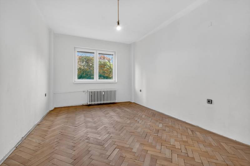 I PREDAJ Priestranný 3-izb. byt v centre Krížna/Blumentálska - Prázdna miestnosť s bielymi stenami a podlahou s dreveným dekorom v 3-izbovom byte.