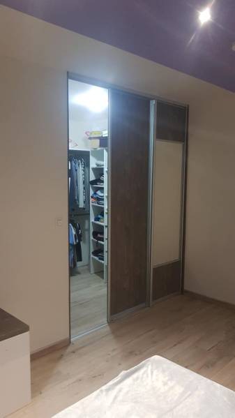 Predaj 4-izbového rodinného domu s veľkou záhradou v Semerove - Šatník s posuvnými dverami a podlahou s dreveným dekorom v rodinnom dome.