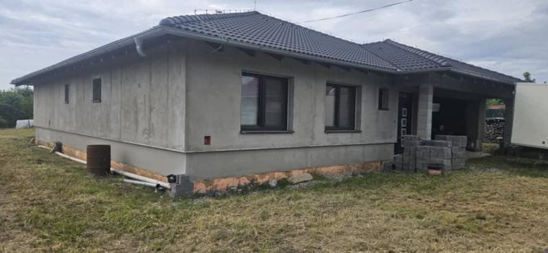 Predaj 4-izbového rodinného domu s veľkou záhradou v Semerove - Rodinný dom z neomietnutých stien v Semerove s šindľovou strechou na trávnatom pozemku.