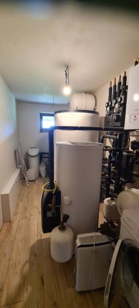 Predaj 4-izbového rodinného domu s veľkou záhradou v Semerove - Technická miestnosť v rodinnom dome s kotlom, nádržami a podlahou s dreveným dekorom.