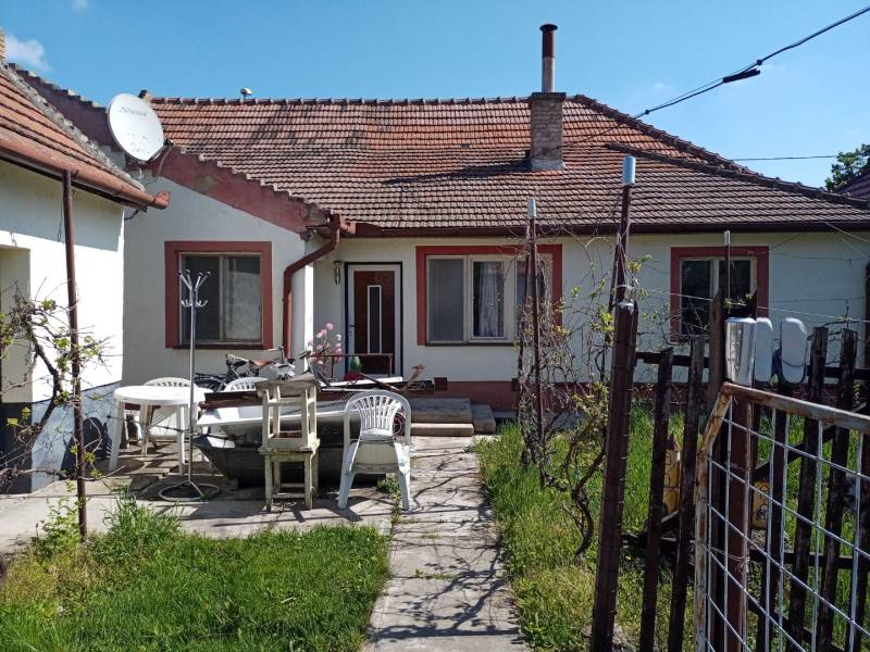 Na predaj rodinný dom v super lokalite - Rodinný dom v Nových Zámkoch s terasou, plastovými stoličkami a satelitnou anténou.