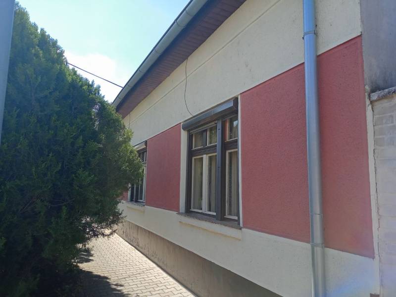 Na predaj rodinný dom v super lokalite - Rodinný dom v Nových Zámkoch so sieťami na zateplenej fasáde a stromom pri chodníku.