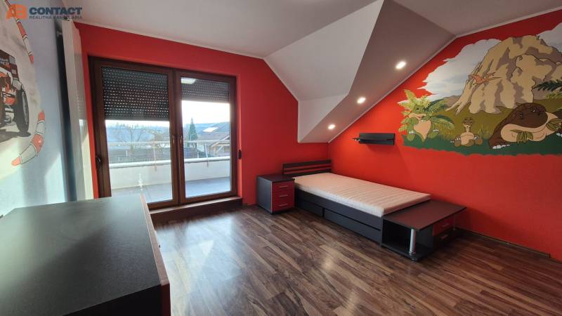 Reprezentatívny 5-izbový rodinný dom pri Piešťanoch - Detská izba so stenou s motívom dinosaurov a podlahou s dreveným dekorom v rodinnom dome.