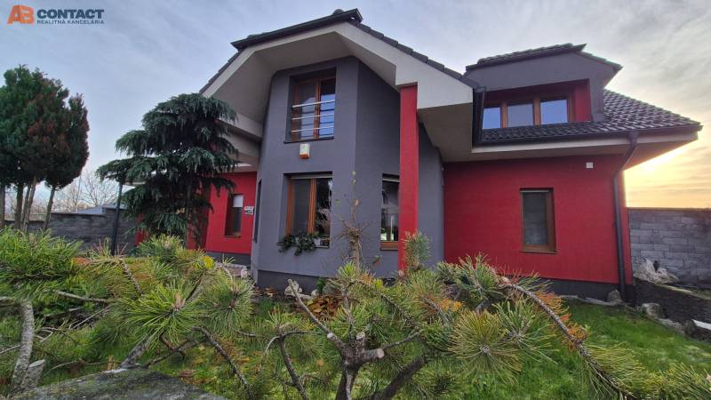 Reprezentatívny 5-izbový rodinný dom pri Piešťanoch - Rodinný dom na Veterná ulici v Krakovanách, obklopený stromami a upravenou záhradou.