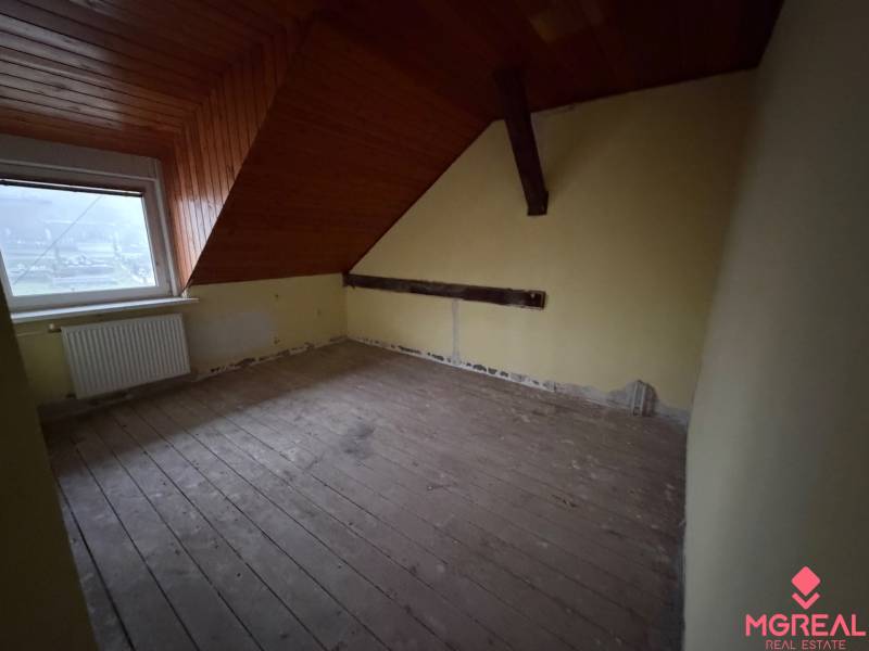 Veľký rodinný dom Podhradie  - Podkrovná miestnosť s dreveným stropom a podlahou s dreveným dekorom v rodinnom dome.