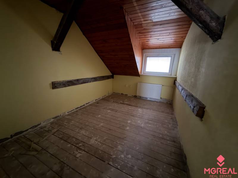 Veľký rodinný dom Podhradie  - Podkrovná izba s podlahou s dreveným dekorom v rodinnom dome.