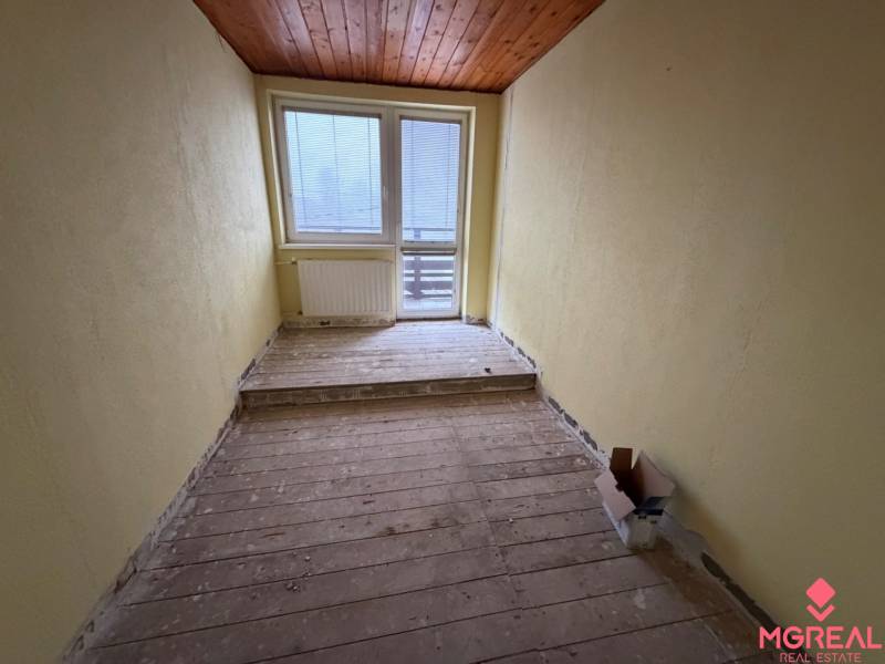 Veľký rodinný dom Podhradie  - Útulná miestnosť s dreveným dekorom a veľkým oknom v rodinnom dome.