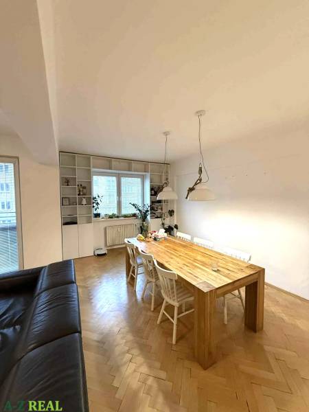 Prenájom 4 izb. bytu, Blumentálska ulica, Staré Mesto - Jedálenský stôl v 4-izbovom byte s podlahou s dreveným dekorom a bielymi stoličkami.