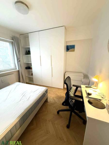 Prenájom 4 izb. bytu, Blumentálska ulica, Staré Mesto - Spálňa v 4-izbovom byte s bielym nábytkom a podlahou s dreveným dekorom.