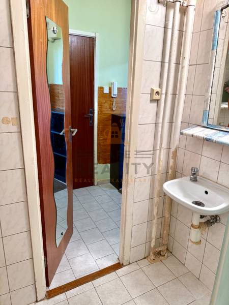 REZERVOVANÉ Na predaj 1 izbový byt, Bratislava, Dúbravka, Drobného - Kúpeľňa v 1-izbovom byte so zrkadlom, umývadlom a bielymi obkladačkami.