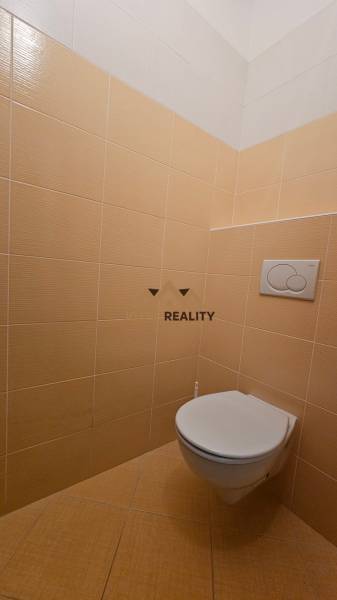 Na prenájom: Nebytový-obchodný priestor – Budovateľská ulica, Šaľa - Toaleta s béžovými kachličkami v obchodných priestoroch.