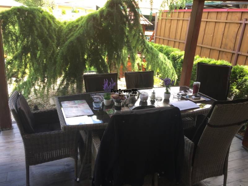 KRÁSNY DVOJPODLAŽNÝ RODINNÝ DOM NA PRENÁJOM - Rodinný dom s posedením na terase, vrátane podlahy s dreveným dekorom a záhradnej zelene.