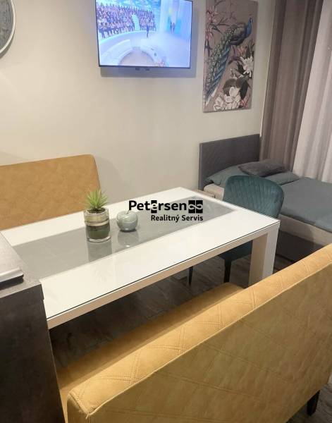 KRÁSNY DVOJPODLAŽNÝ RODINNÝ DOM NA PRENÁJOM - Obývacia časť s TV v rodinnom dome, sklenený stôl, pohovky, obraz páv, podlaha s dreveným dekorom.