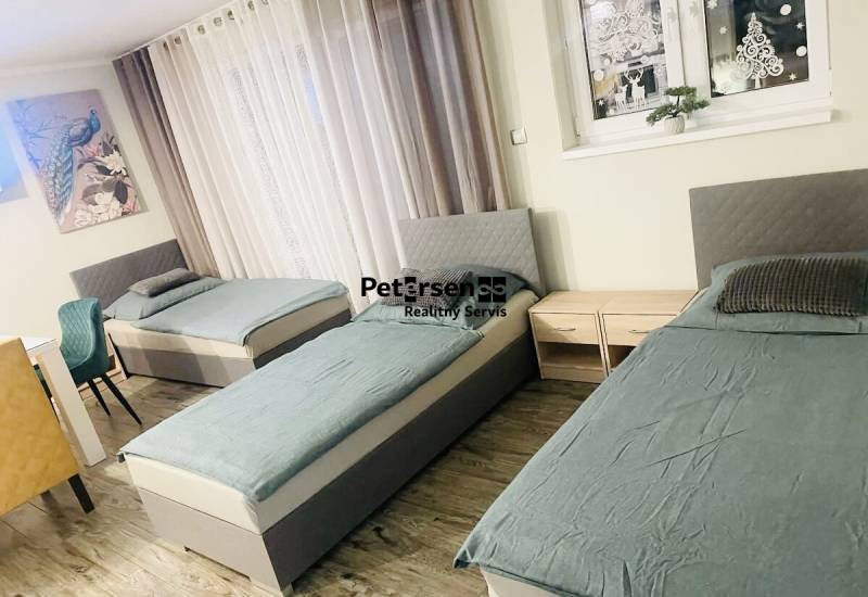 KRÁSNY DVOJPODLAŽNÝ RODINNÝ DOM NA PRENÁJOM - Tri postele, dve nočné stolíky a podlaha s dreveným dekorom v rodinnom dome.