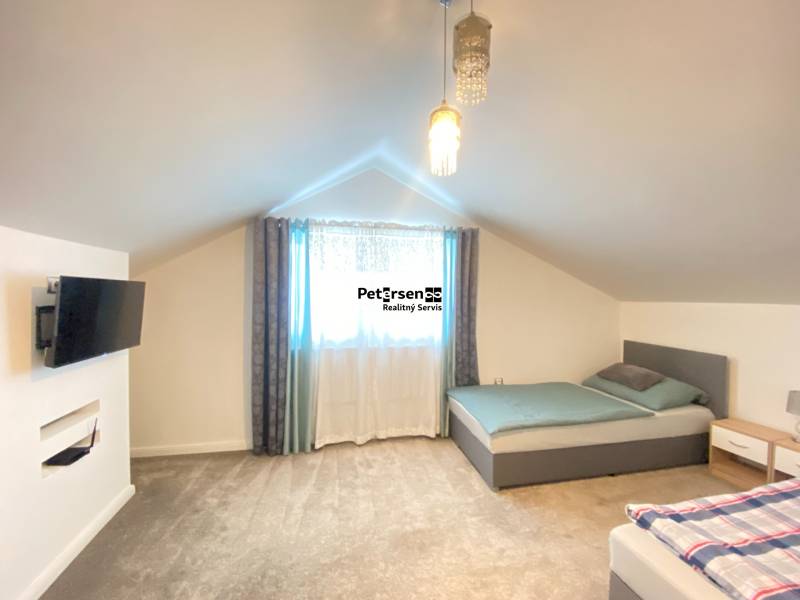 KRÁSNY DVOJPODLAŽNÝ RODINNÝ DOM NA PRENÁJOM - Spálňa v rodinnom dome s dvoma posteľami, televízorom a kobercovou podlahou.