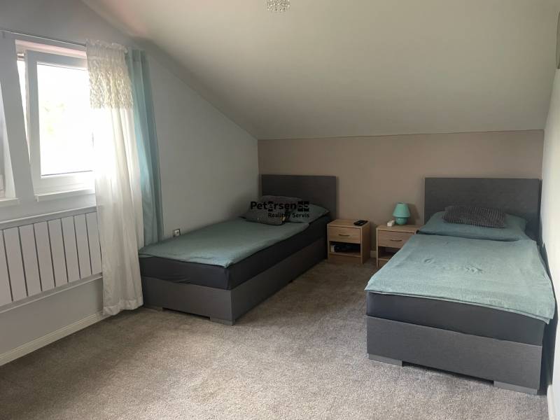 KRÁSNY DVOJPODLAŽNÝ RODINNÝ DOM NA PRENÁJOM - Dvojlôžková izba v rodinnom dome s kobercom a strešným oknom.