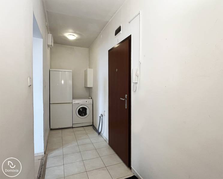 Exkluzívne | Na prenájom priestranný 1i byt Ružinove - Predsieň 1-izbového bytu s práčkou a chladničkou. Biele steny, keramická podlaha.