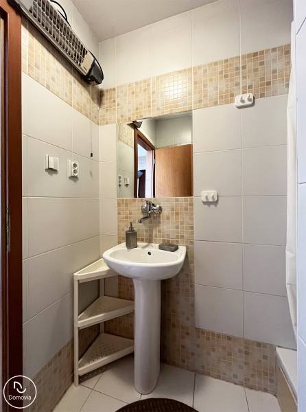 Exkluzívne | Na prenájom priestranný 1i byt Ružinove - Kúpeľňa v 1-izbovom byte s umývadlom, zrkadlom a bielymi obkladačkami.
