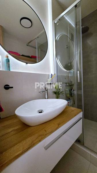 Moderný, rekonštruovaný 3i byt, pivnica, Jašíkova ul., Ružinov - Pošeň - Kúpeľňa so sprchovým kútom, umývadlom a podlahou s dreveným dekorom v 3-izbovom byte.