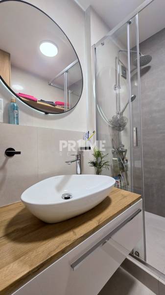 Moderný, rekonštruovaný 3i byt, pivnica, Jašíkova ul., Ružinov - Pošeň - Kúpeľňa v 3-izbovom byte s umývadlom na drevenom dekore, zrkadlom a sprchovým kútom.
