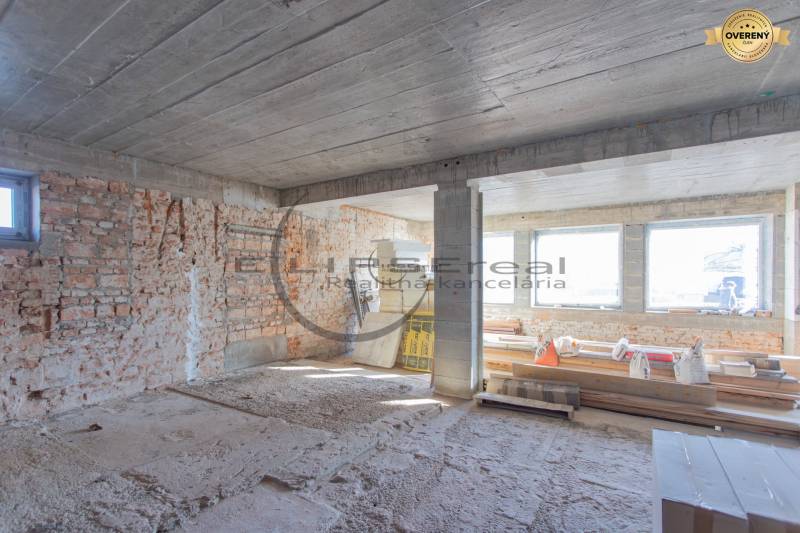 NA PREDAJ polyfunkčná budova v centre obce Veľké Leváre - Stavenisko v budove s tehlovými stenami a veľkými oknami. Stavba je v štádiu výstavby.