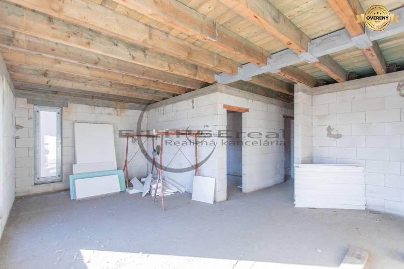 NA PREDAJ polyfunkčná budova v centre obce Veľké Leváre - Budova vo výstavbe s dreveným stropom a stavebným materiálom v interiéri.