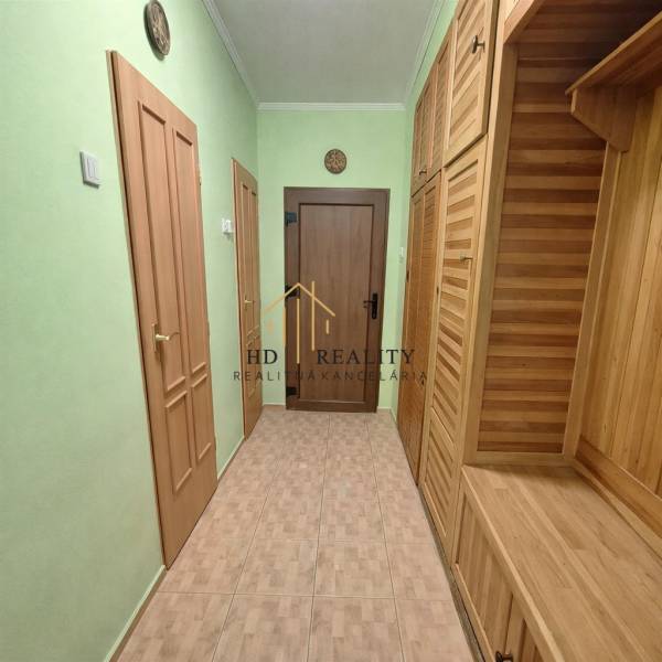 Predaj 2 izbový byt s dvoma balkónmi v Nižnej. - Chodba v 2-izbovom byte s dreveným dekorom a zelenými stenami.