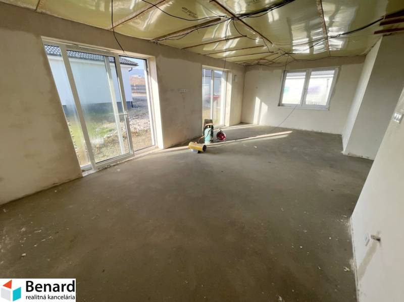 DOKONČENÁ NOVOSTAVBA,SOĽ-VRANOV N. TOPĽOU,MOŽNÁ DOHODA - Priestorná miestnosť v rodinnom dome so surovou betónovou podlahou, veľké okná poskytujú dostatok svetla.