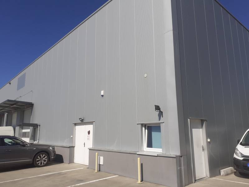 Prenájom skladu 670 m2 neďaleko letiska, IKEA - Sklady a haly na Technickej ulici v Bratislave-Ružinove, s parkovanými autami pred vstupom.