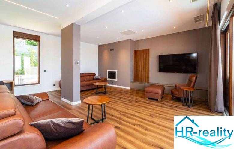 Novalja – luxusná vila s bazénom, jacuzzi a výhľadom na more - Obývacia izba vo vile s podlahou s dreveným dekorom, koženou sedačkou a televízorom.