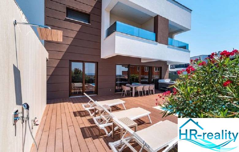 Novalja – luxusná vila s bazénom, jacuzzi a výhľadom na more - Terasa s ležadlami pri vile v Novalji s výhľadom na more a sprchou.