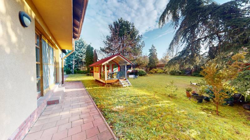 Veľkometrážny dom s wellness, bazénom a investičným potenciálom - Záhrada rodinného domu na ulici SNP v Ivanke pri Dunaji s detským dreveným domčekom.