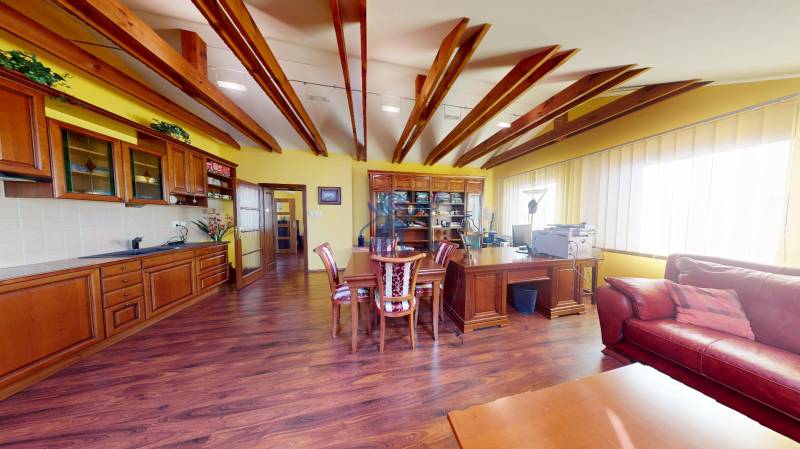 Veľkometrážny dom s wellness, bazénom a investičným potenciálom - Rodinný dom s kuchyňou, podlahou s dreveným dekorom a kúskom pracoviska v rohu miestnosti.