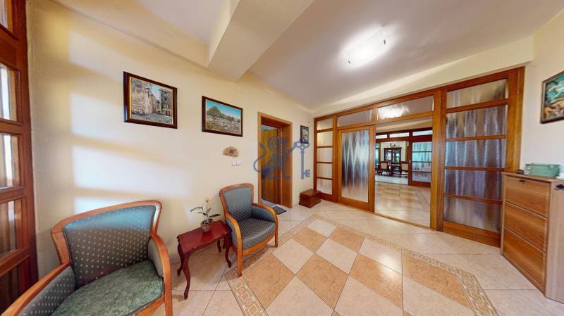 Veľkometrážny dom s wellness, bazénom a investičným potenciálom - Chodba v rodinnom dome s pohodlnými kreslami, stolíkom a dlaždicovou podlahou.