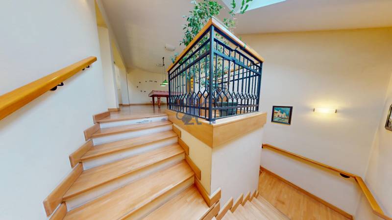 Veľkometrážny dom s wellness, bazénom a investičným potenciálom - Schodisko v rodinnom dome s podlahou s dreveným dekorom a rastlinami na poschodí.