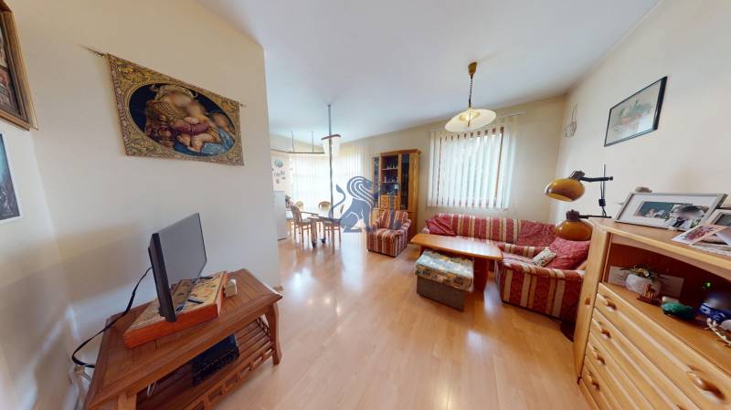 Veľkometrážny dom s wellness, bazénom a investičným potenciálom - Obývacia izba v rodinnom dome s podlahou s dreveným dekorom, útulnou sedačkou a dekoráciami.