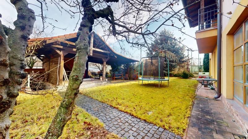 Veľkometrážny dom s wellness, bazénom a investičným potenciálom - Záhrada rodinného domu s trampolínou a altánkom v Ivanke pri Dunaji na ulici SNP.