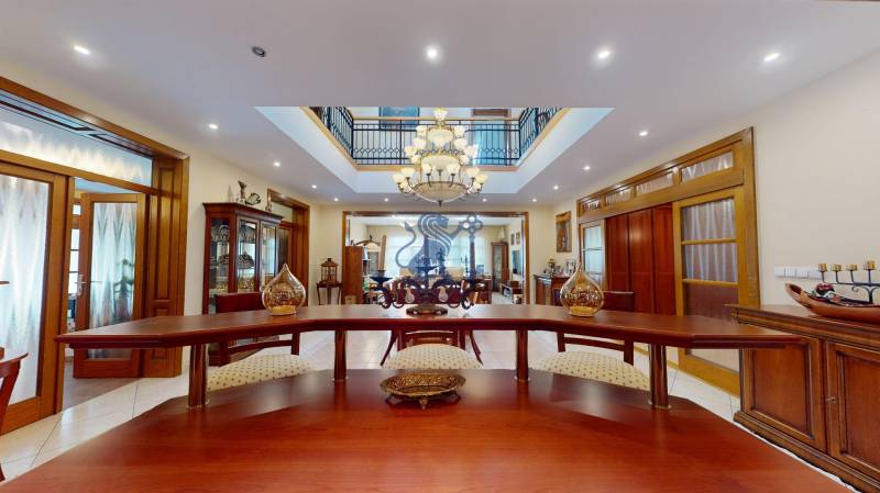 Veľkometrážny dom s wellness, bazénom a investičným potenciálom - Interiér rodinného domu so štýlovým nábytkom, lustrom a podlahou s dreveným dekorom.