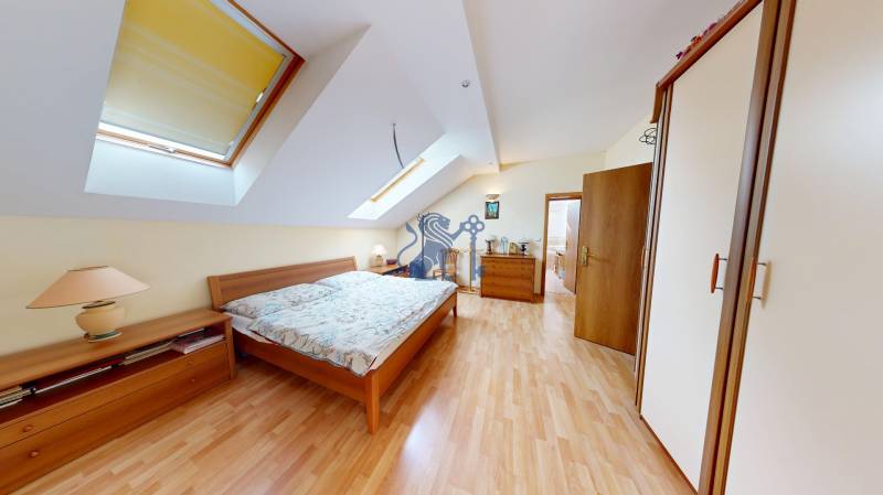 Veľkometrážny dom s wellness, bazénom a investičným potenciálom - Spálňa v rodinnom dome s dvojitou posteľou, šatníkom a podlahou s dreveným dekorom.