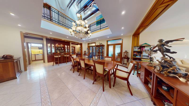 Veľkometrážny dom s wellness, bazénom a investičným potenciálom - Jedáleň v Rodinnom dome s veľkým dreveným stolom, lustrom a dekoráciami.