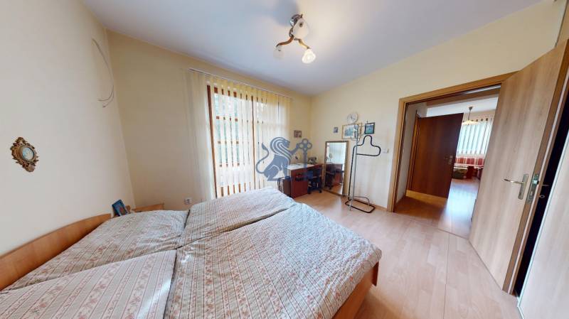 Veľkometrážny dom s wellness, bazénom a investičným potenciálom - Spálňa s dvojposteľou a stolíkom, podlaha s dreveným dekorom v rodinnom dome.