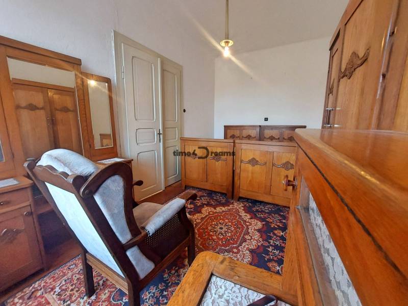 NA PREDAJ rodinný dom - Lehota nad Rimavicou - Rodinný dom s retro nábytkom, starodávny koberec, kreslo, drevená skriňa a zrkadlo.