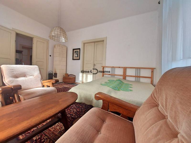 NA PREDAJ rodinný dom - Lehota nad Rimavicou - Interiér rodinného domu s pohodlnými kreslami, drevom obloženými stolmi a kachľovou pecou.