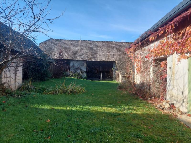 NA PREDAJ rodinný dom - Lehota nad Rimavicou - Záhrada s rodinným domom, stromy bez lístia a tráva obklopené múrmi.